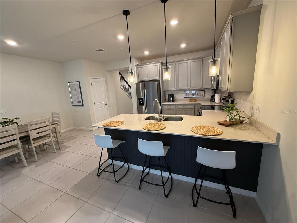 10923 Leafshore Loop Orlando, FL 32829 - Photo 6 of 44 a kitchen with a dining table chairs and sink