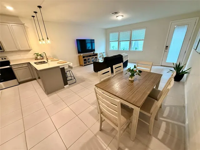 a living room with furniture a flat screen tv and a window