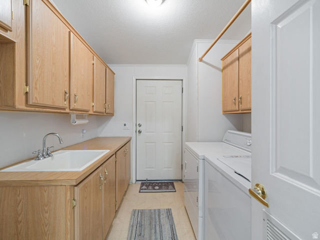 3941 West 40 North Hurricane, UT 84737 - Photo 31 of 55 Utility room featuring extensive wood-finish cabinetry, a dedicated sink with a chrome faucet, and a clothes hanging rod