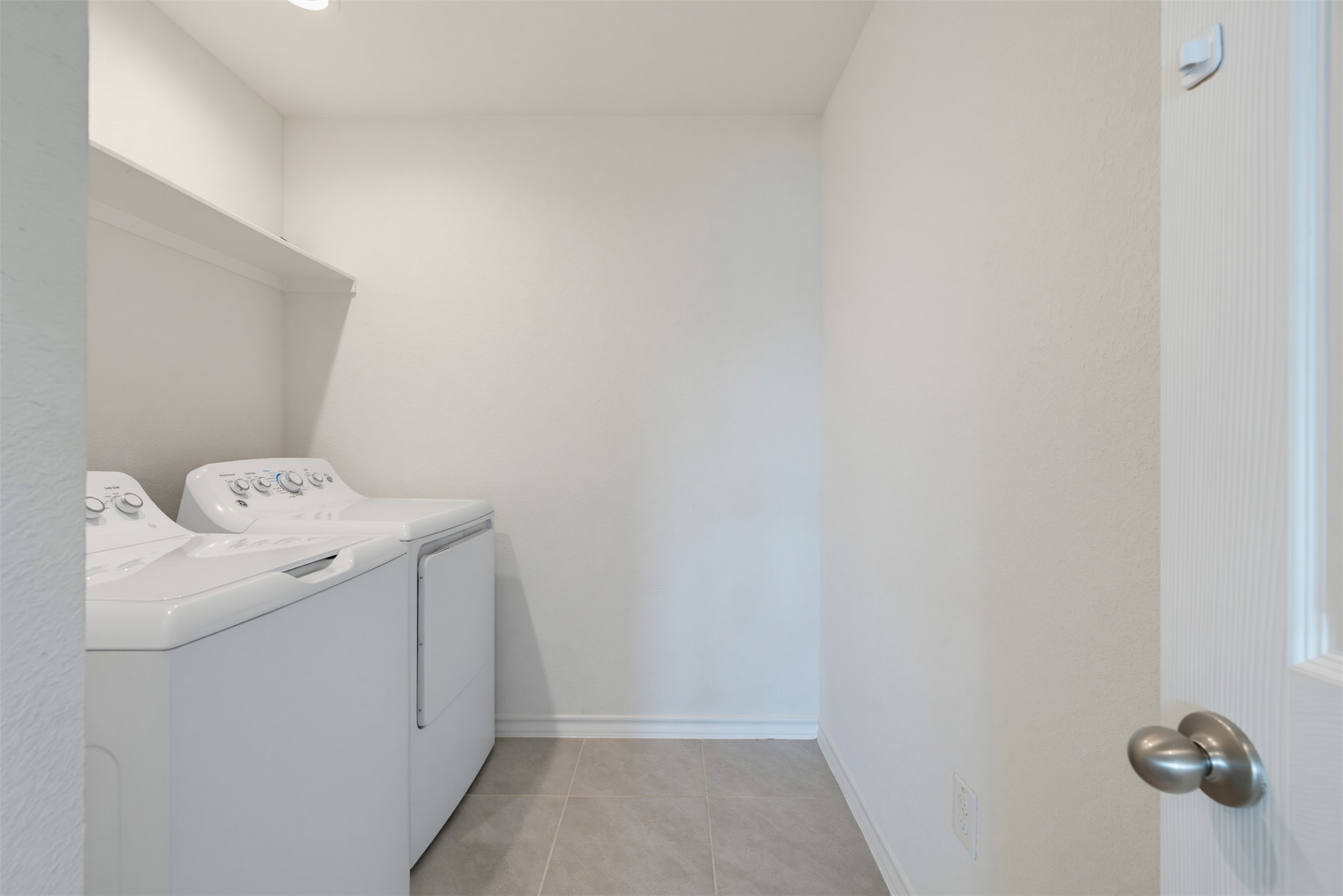 11008 Players Path Austin, TX 78747 - Photo 21 of 26 A functional laundry space highlights tiled flooring and high-quality appliances for ultimate convenience.