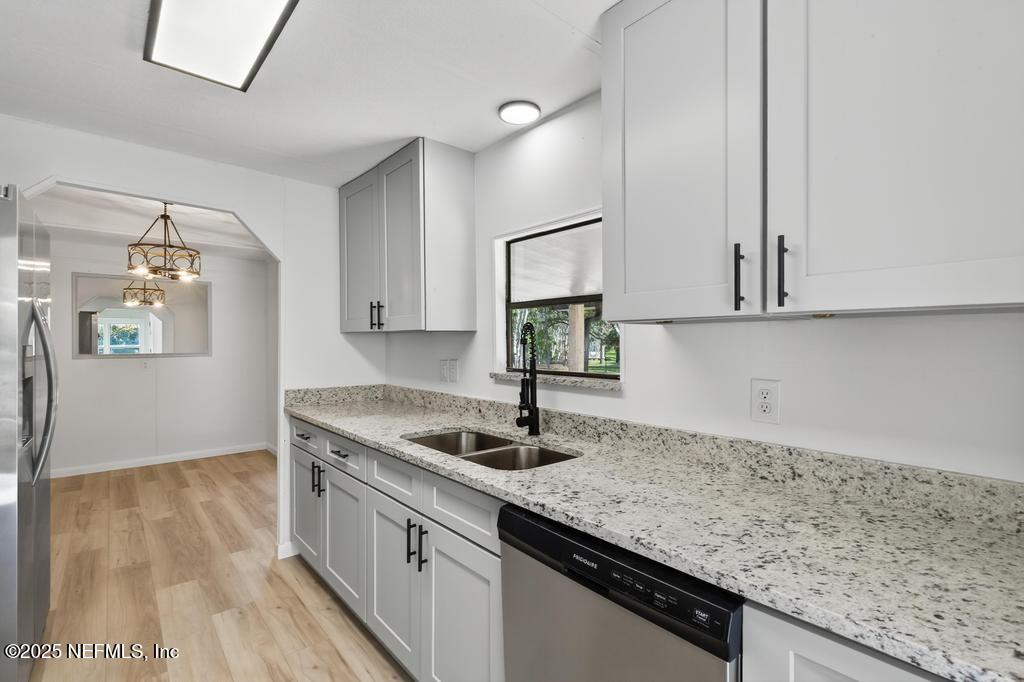 560 Quarter Horse Lane Bunnell, FL 32110 - Photo 18 of 66 a kitchen with stainless steel appliances granite countertop a sink dishwasher and stove with wooden floor