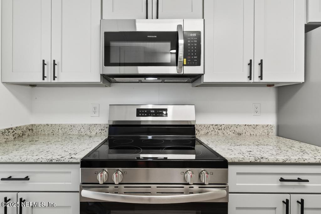 560 Quarter Horse Lane Bunnell, FL 32110 - Photo 20 of 66 a kitchen with granite countertop a stove and a microwave