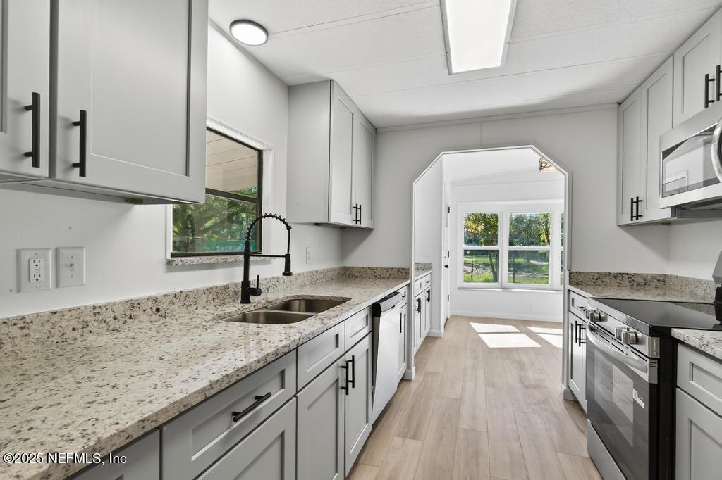 560 Quarter Horse Lane Bunnell, FL 32110 - Photo 22 of 66 a kitchen with granite countertop a sink and a stove