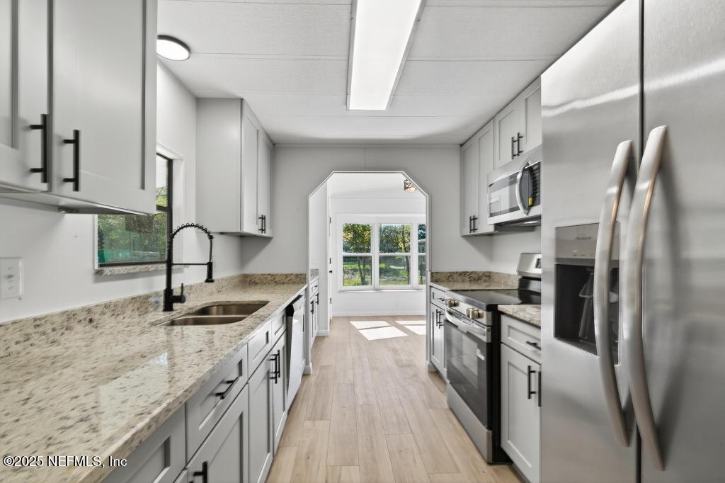 560 Quarter Horse Lane Bunnell, FL 32110 - Photo 23 of 66 a kitchen with stainless steel appliances granite countertop a sink stove and refrigerator