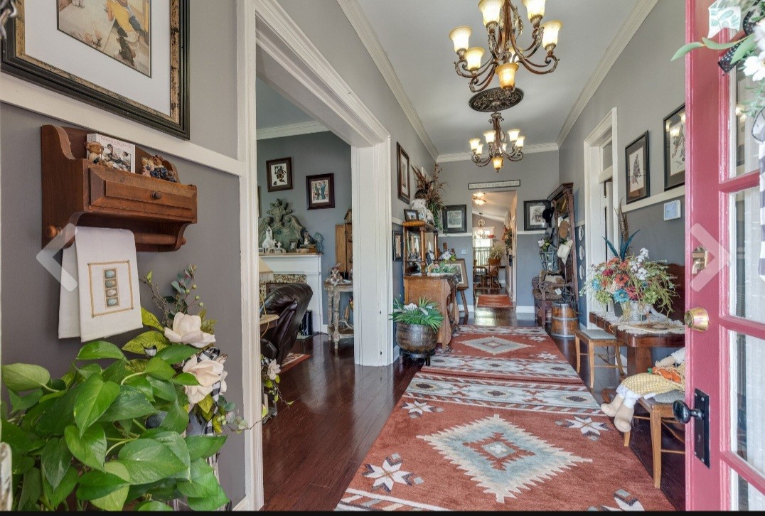 210 South 6th Street Pulaski, TN 38478 - Photo 9 of 44 a view of a hallway with a dining table a chandelier and a rug