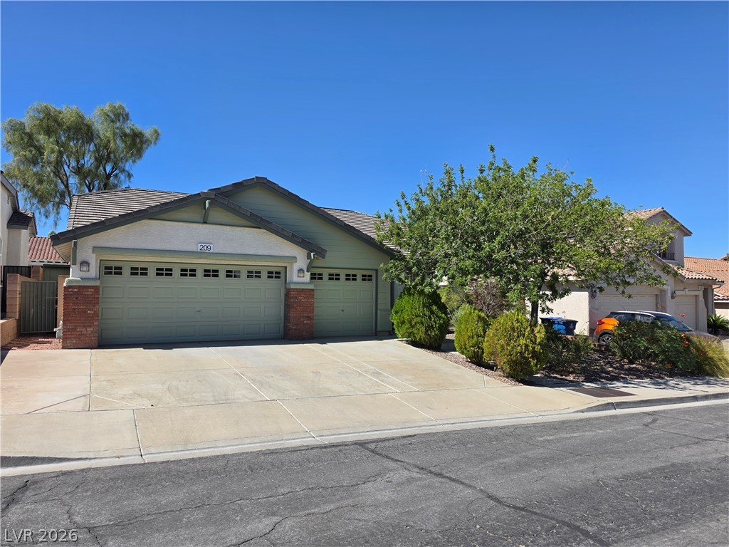 209 Opera House Street Henderson, NV 89012 - Photo 38 of 45 A spacious driveway leads to this classic suburban home under a clear blue sky.
