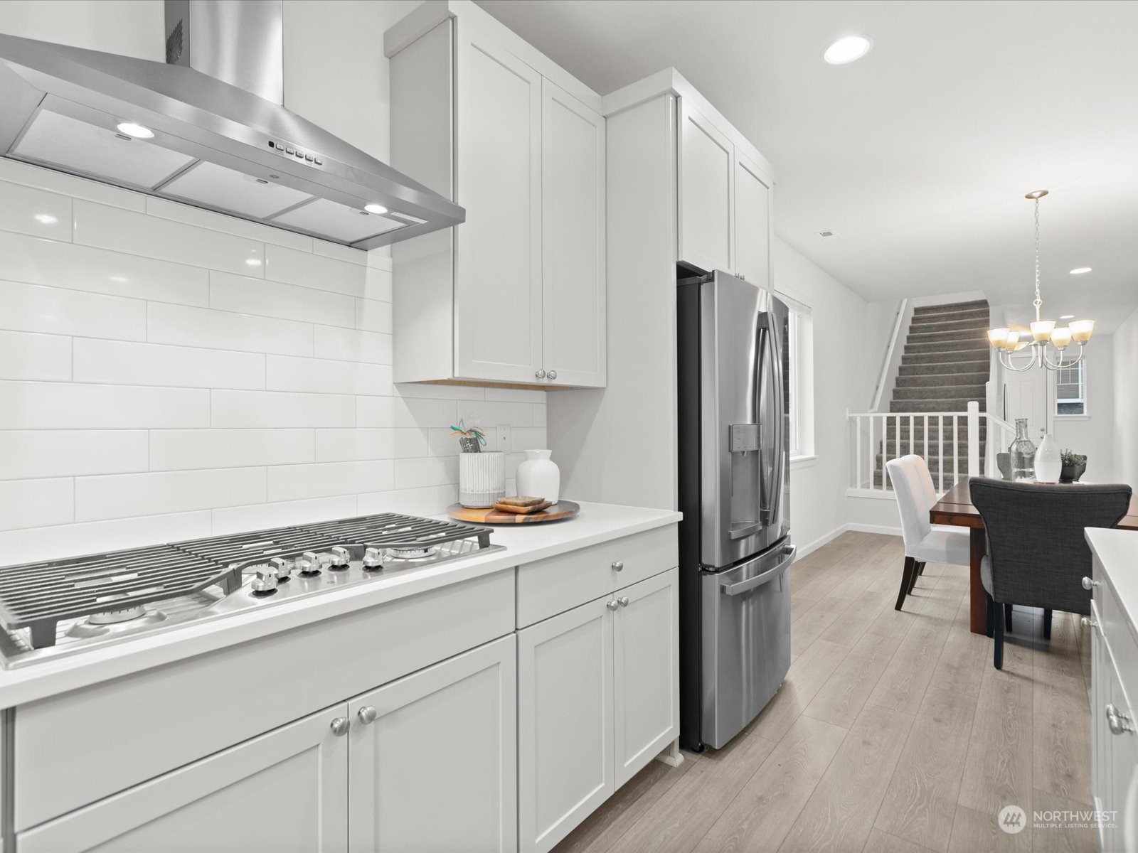9752 Prospect Place Gig Harbor, WA 98332 - Photo 12 of 40 a kitchen with kitchen island a counter space a stove a refrigerator and chairs