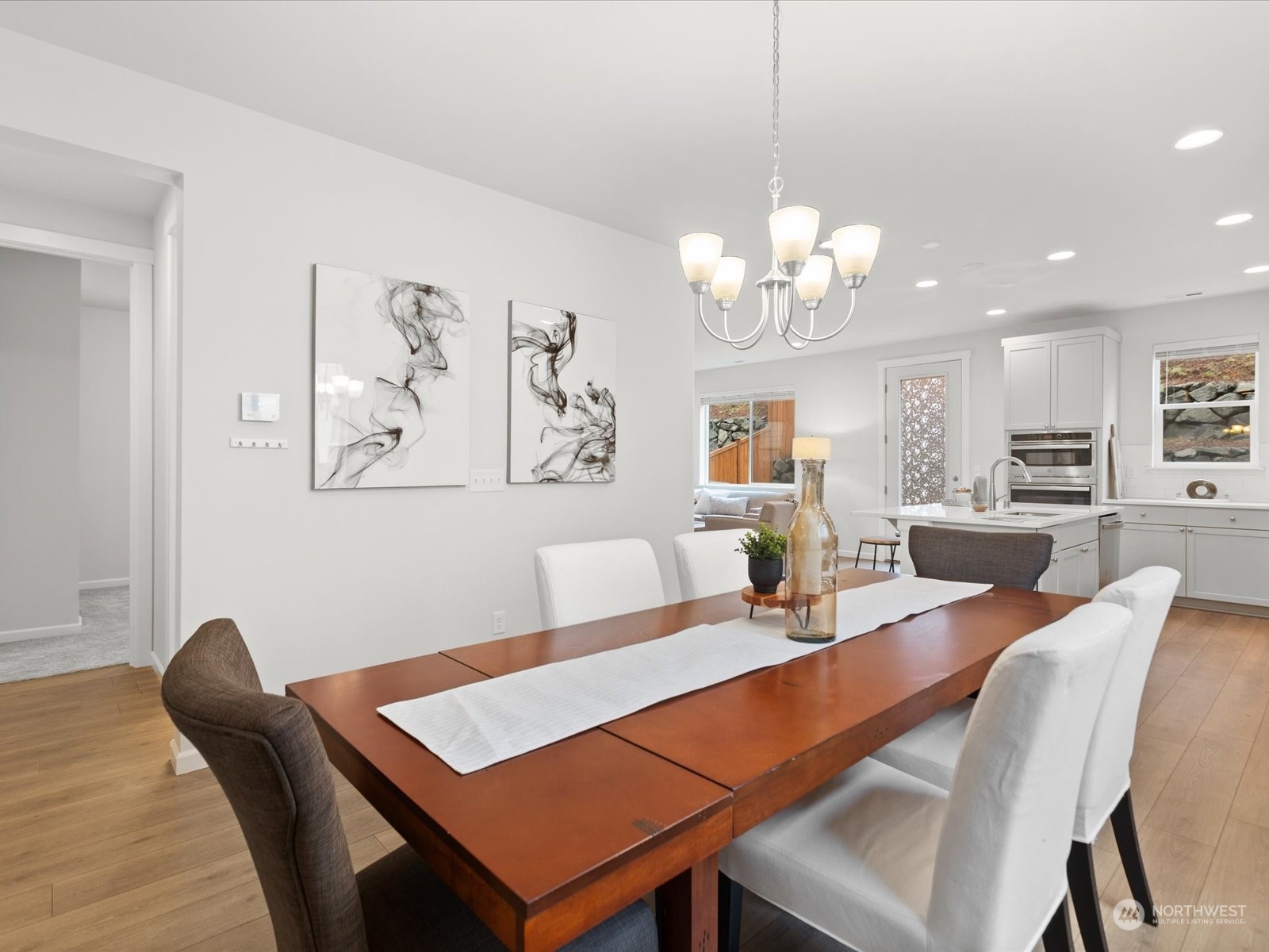 9752 Prospect Place Gig Harbor, WA 98332 - Photo 8 of 40 a view of a dining room with furniture a chandelier and wooden floor