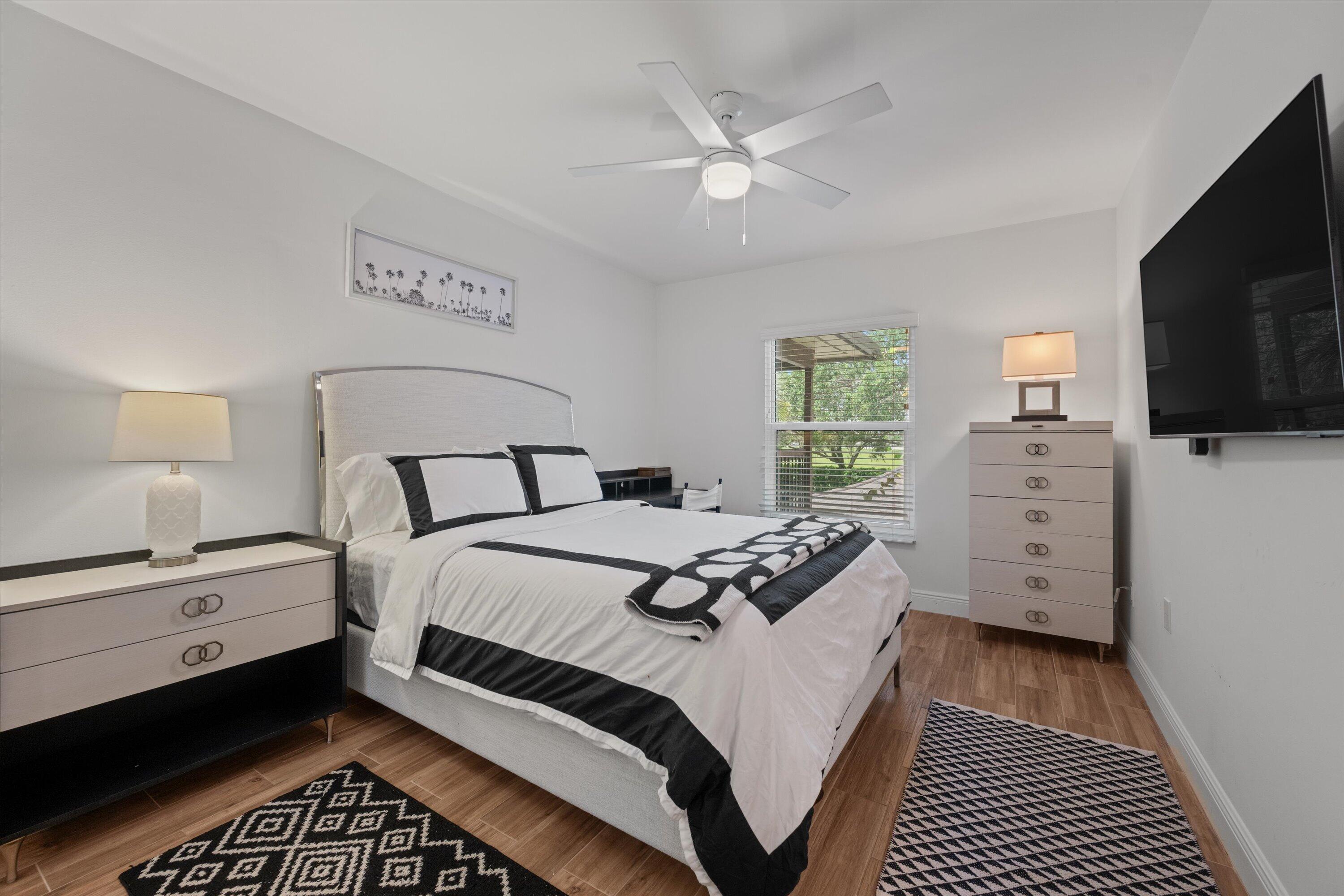 13400 Polo Road West, Unit 203 Wellington, FL 33414 - Photo 20 of 26 a bedroom with a bed and a flat tv screen on dresser