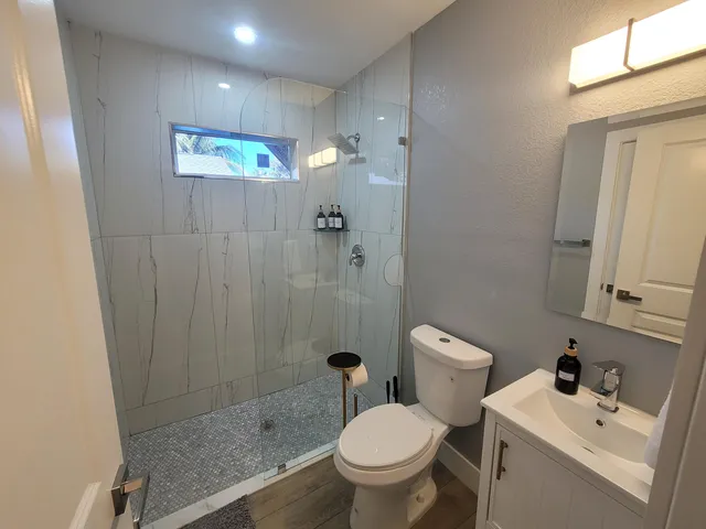 a bathroom with a sink a toilet and shower