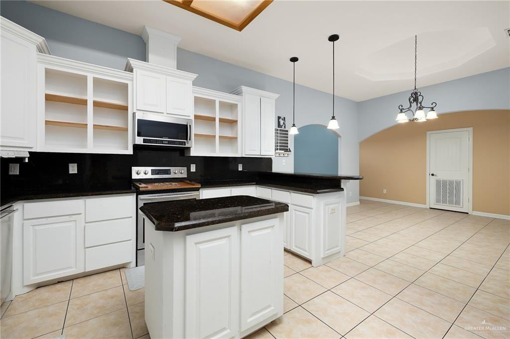 1236 Chloe Rae Circle Weslaco, TX 78599 - Photo 9 of 30 a kitchen with stainless steel appliances a stove a sink a kitchen island a cabinets and chairs