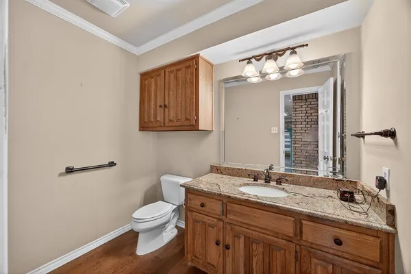 a bathroom with a granite countertop toilet sink and mirror