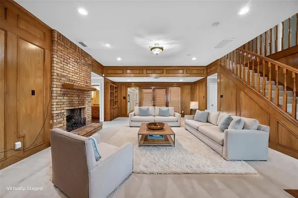 a living room with furniture fireplace and a large window