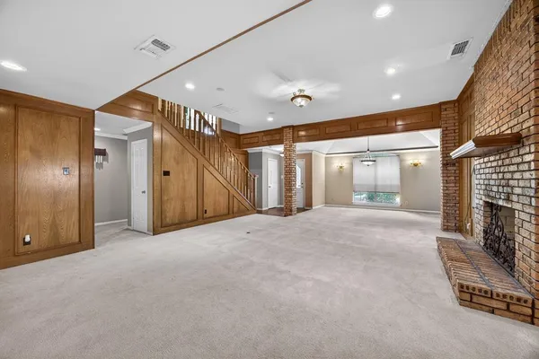 a view of empty room with floor to ceiling window and fireplace