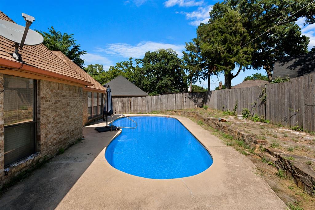3506 Ruidoso Drive Arlington, TX 76017 - Photo 36 of 37 Backyard swimming pool with a concrete surround, wood privacy fencing, and mature trees