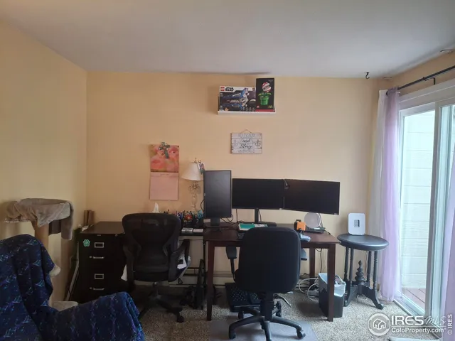 a view of a workspace with furniture and a window