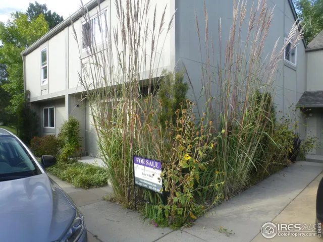 a car parked in front of a white house