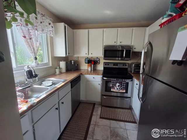 a kitchen with granite countertop a refrigerator stove and sink