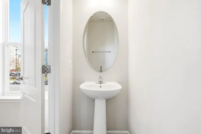 a bathroom with a sink a mirror and a light fixture