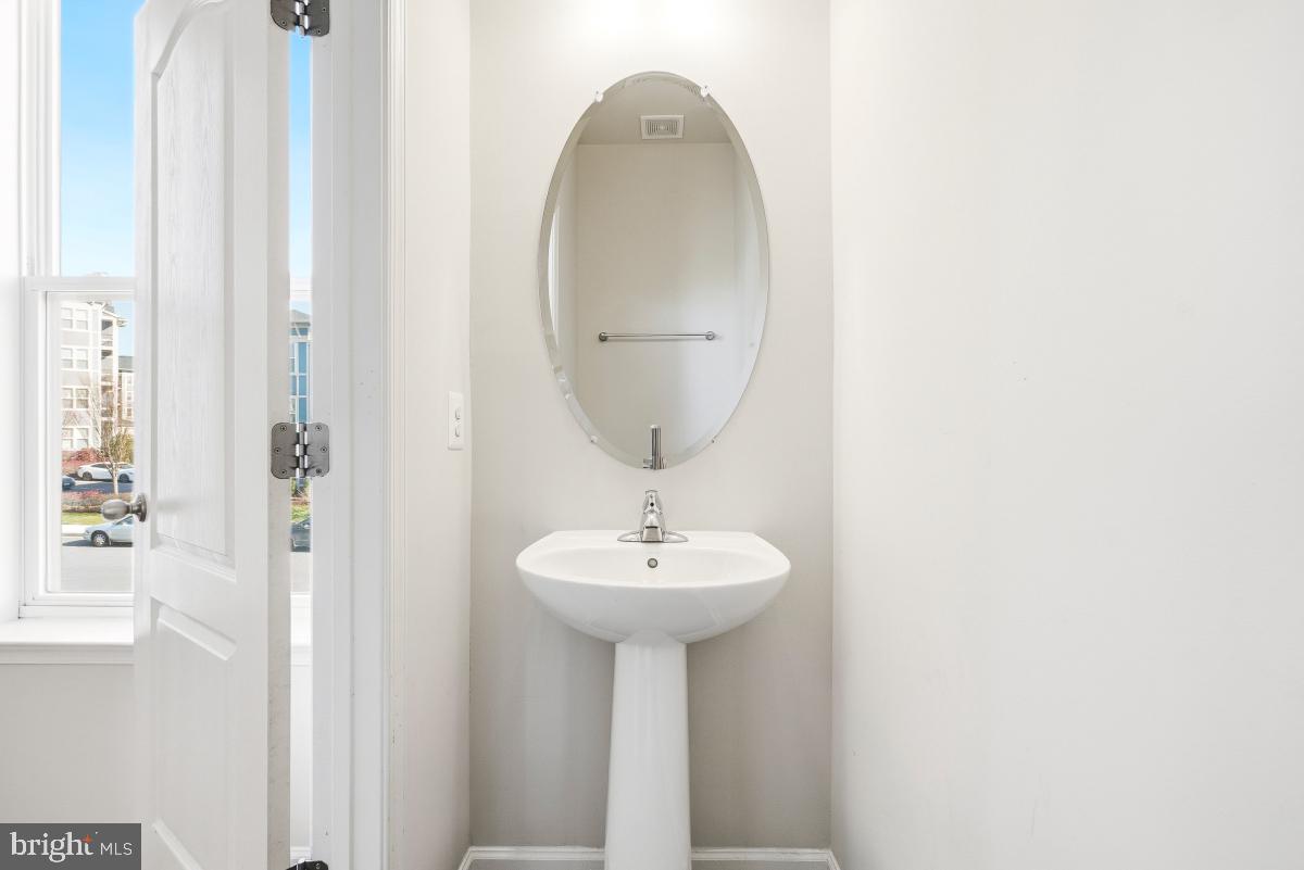 5820 Imperial Drive Frederick, MD 21703 - Photo 17 of 30 a bathroom with a sink a mirror and a light fixture