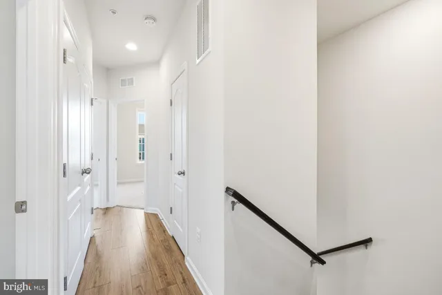 a view of a hallway with wooden floor and staircase