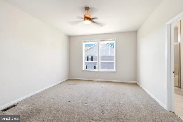 an empty room with windows and ceiling fan