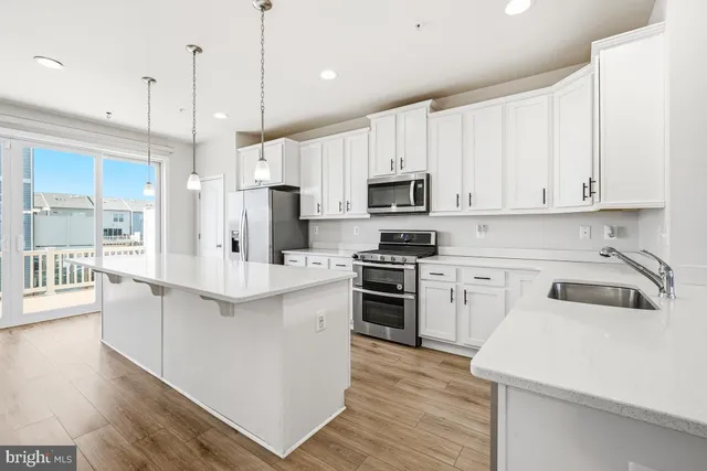 a kitchen with kitchen island white cabinets stainless steel appliances and sink