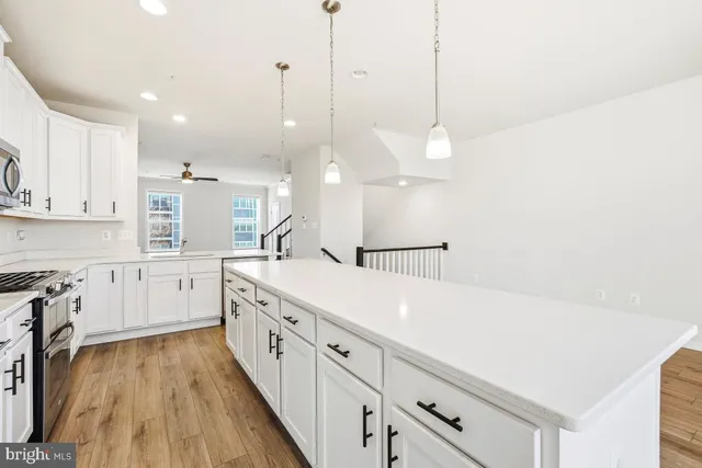 a large white kitchen with lots of counter space sink and appliances