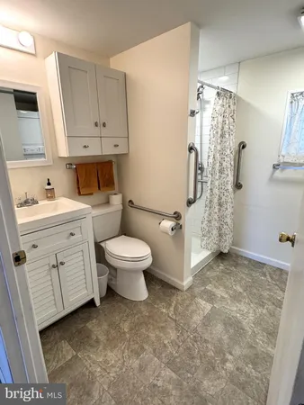 a bathroom with a granite countertop sink a toilet and a shower