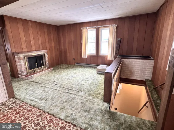 a view of an empty room with window and stairs
