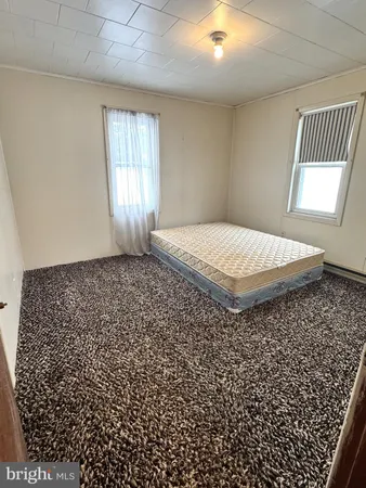 a spacious bedroom with a bed and a window