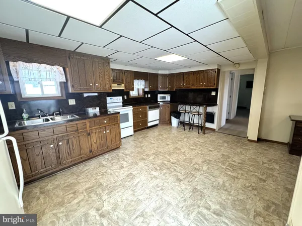 a open kitchen with cabinets a sink and appliances
