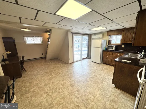 a kitchen with granite countertop a stove a sink and a refrigerator