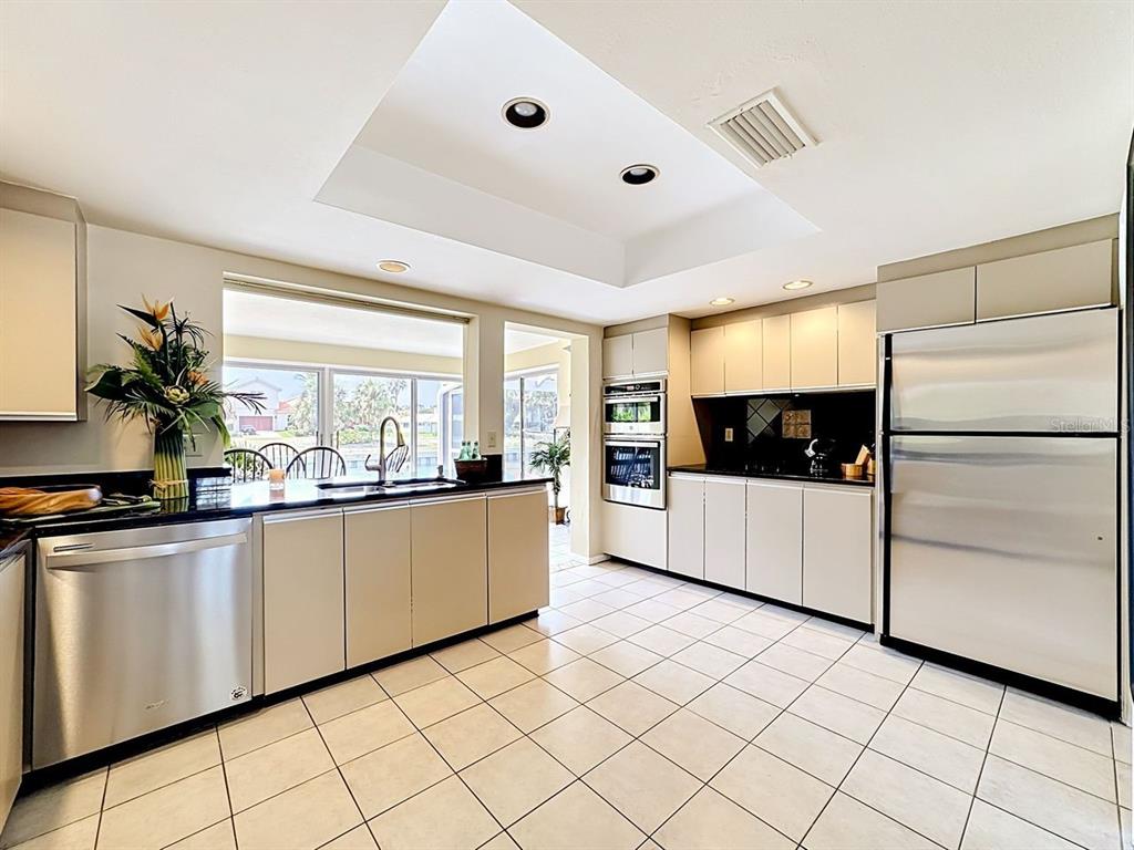 581 Yardarm Lane Longboat Key, FL 34228 - Photo 7 of 30 a kitchen with granite countertop white cabinets and white appliances