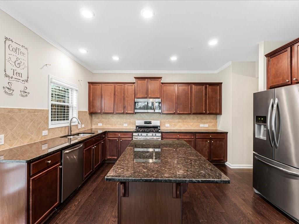 365 Williamson Street Southeast Marietta, GA 30060 - Photo 12 of 28 a kitchen with kitchen island granite countertop stainless steel appliances a sink a stove a refrigerator cabinets and a center island
