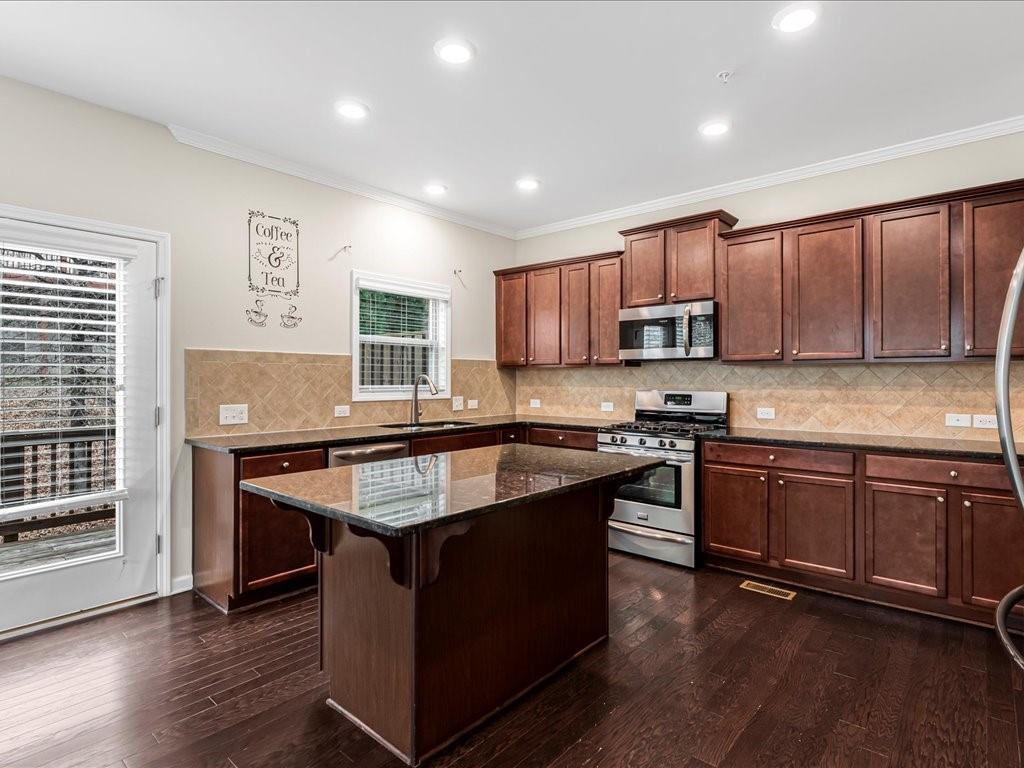 365 Williamson Street Southeast Marietta, GA 30060 - Photo 15 of 28 a kitchen with kitchen island granite countertop wooden cabinets and a stove