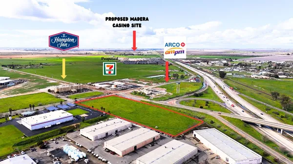 a view of a tennis ground with a table and chairs