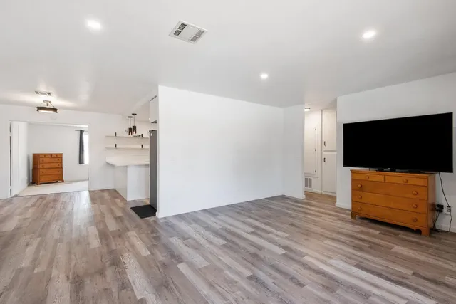 a view of empty room with wooden floor and windows