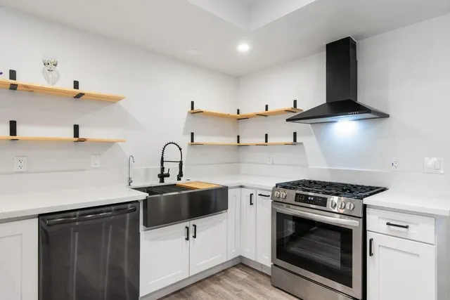a kitchen with granite countertop a sink stainless steel appliances and cabinets