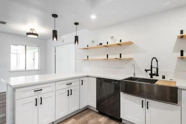 a kitchen with white cabinets a sink and dishwasher