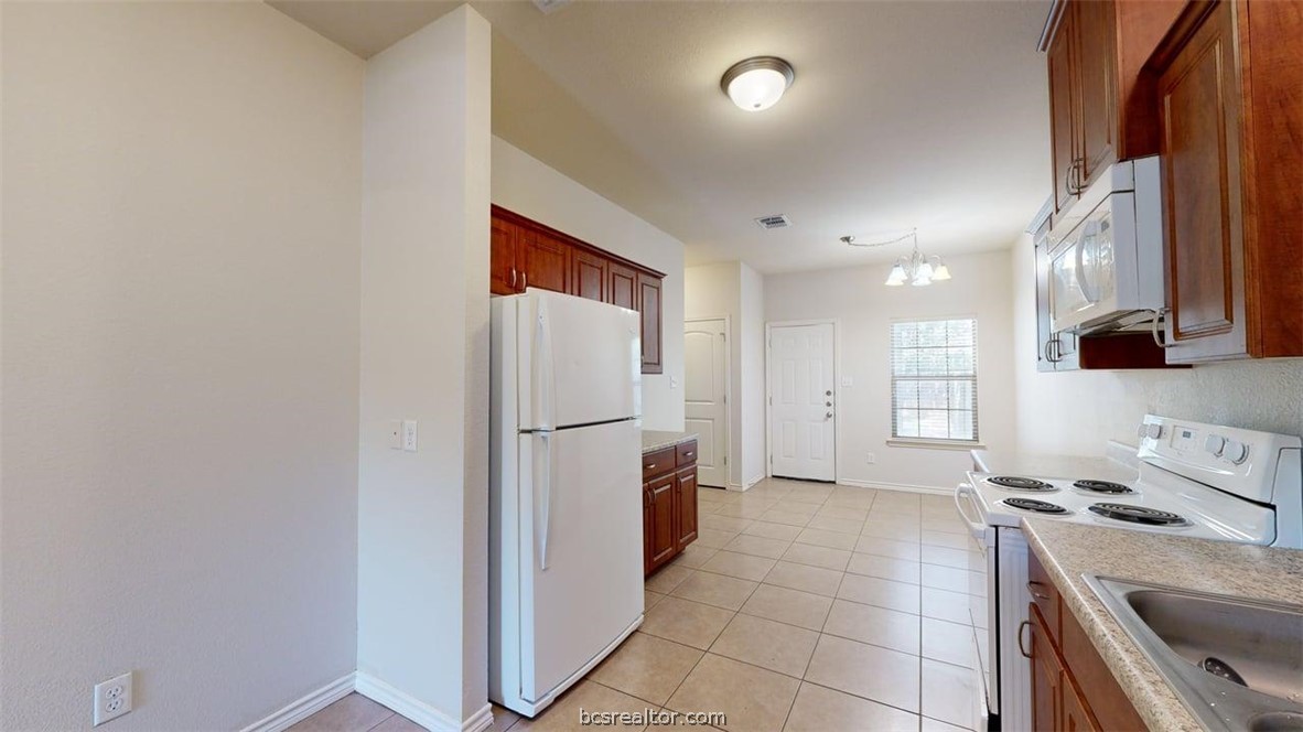 4453-4455 Reveille Road College Station, TX 77845 - Photo 8 of 37 a kitchen with a refrigerator and a stove top oven