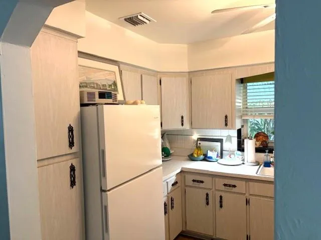 a kitchen with a refrigerator a sink and cabinets
