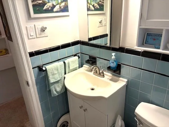 a bathroom with a sink mirror vanity and toilet