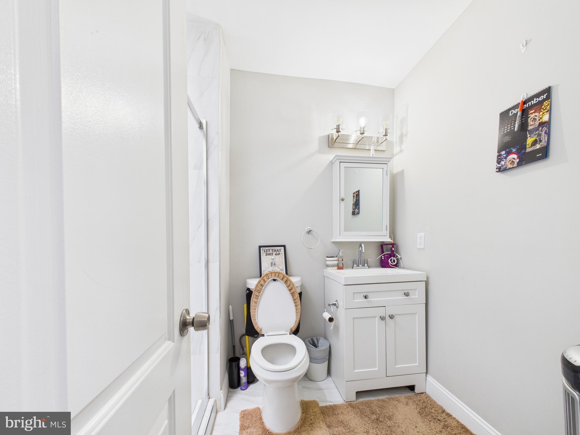 1526 North Patterson Park Avenue Baltimore, MD 21213 - Photo 15 of 31 a bathroom with a sink vanity mirror and toilet