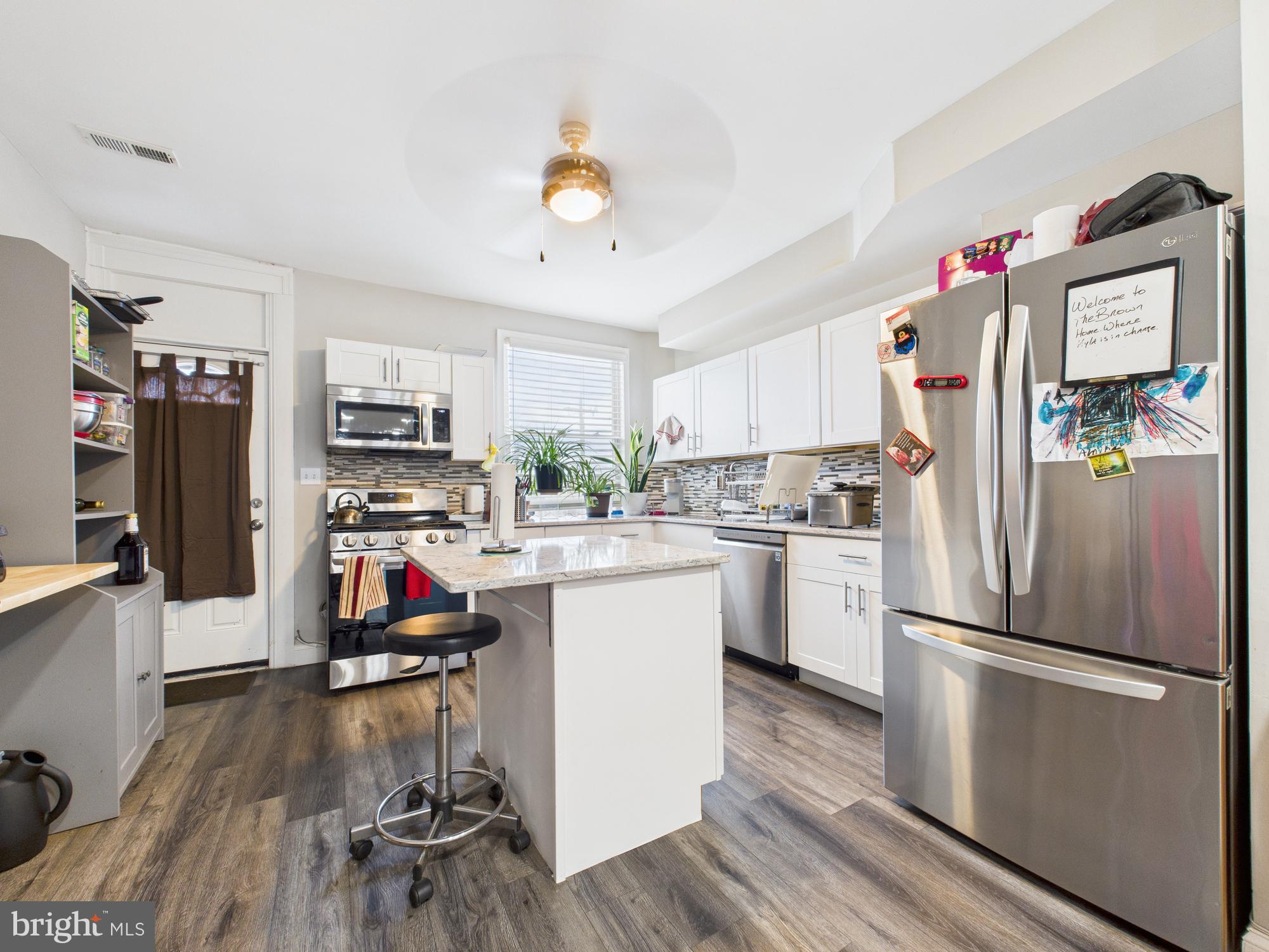 1526 North Patterson Park Avenue Baltimore, MD 21213 - Photo 5 of 31 a kitchen with stainless steel appliances a refrigerator sink and wooden floor