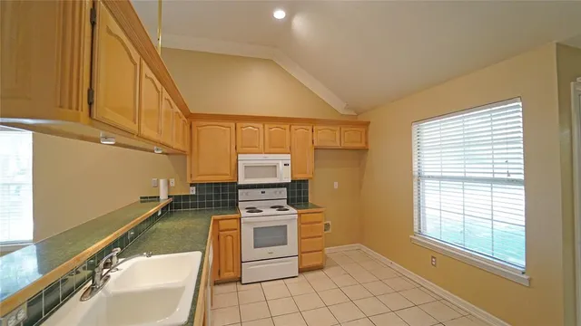 a kitchen with stainless steel appliances a stove a sink and a microwave