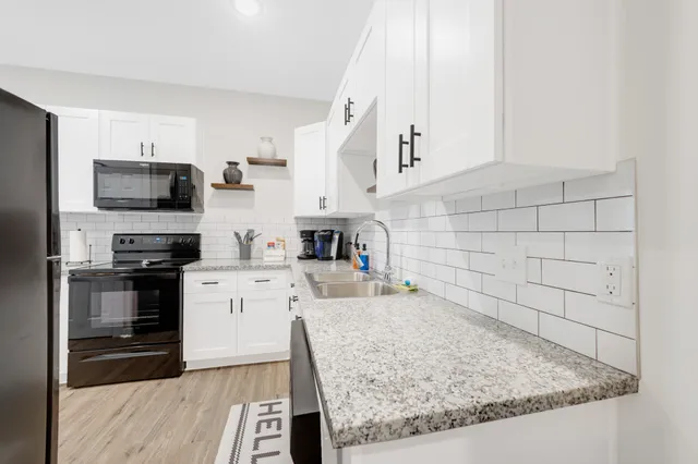 a kitchen with stainless steel appliances granite countertop a sink stove and refrigerator