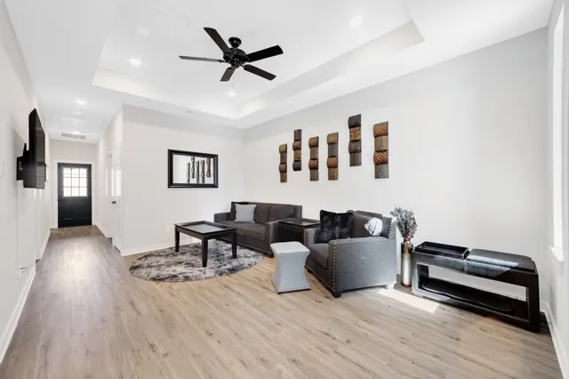 a living room with furniture and a wooden floor