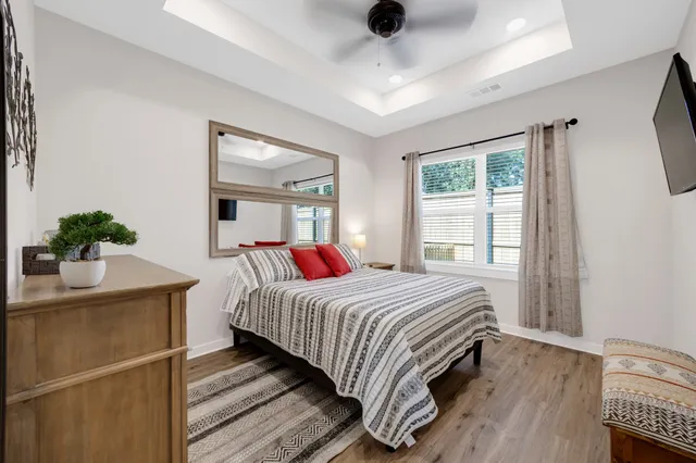 a bedroom with a bed and a potted plant on the dresser