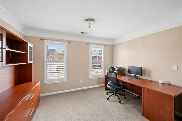 a view of a workspace with furniture and a window